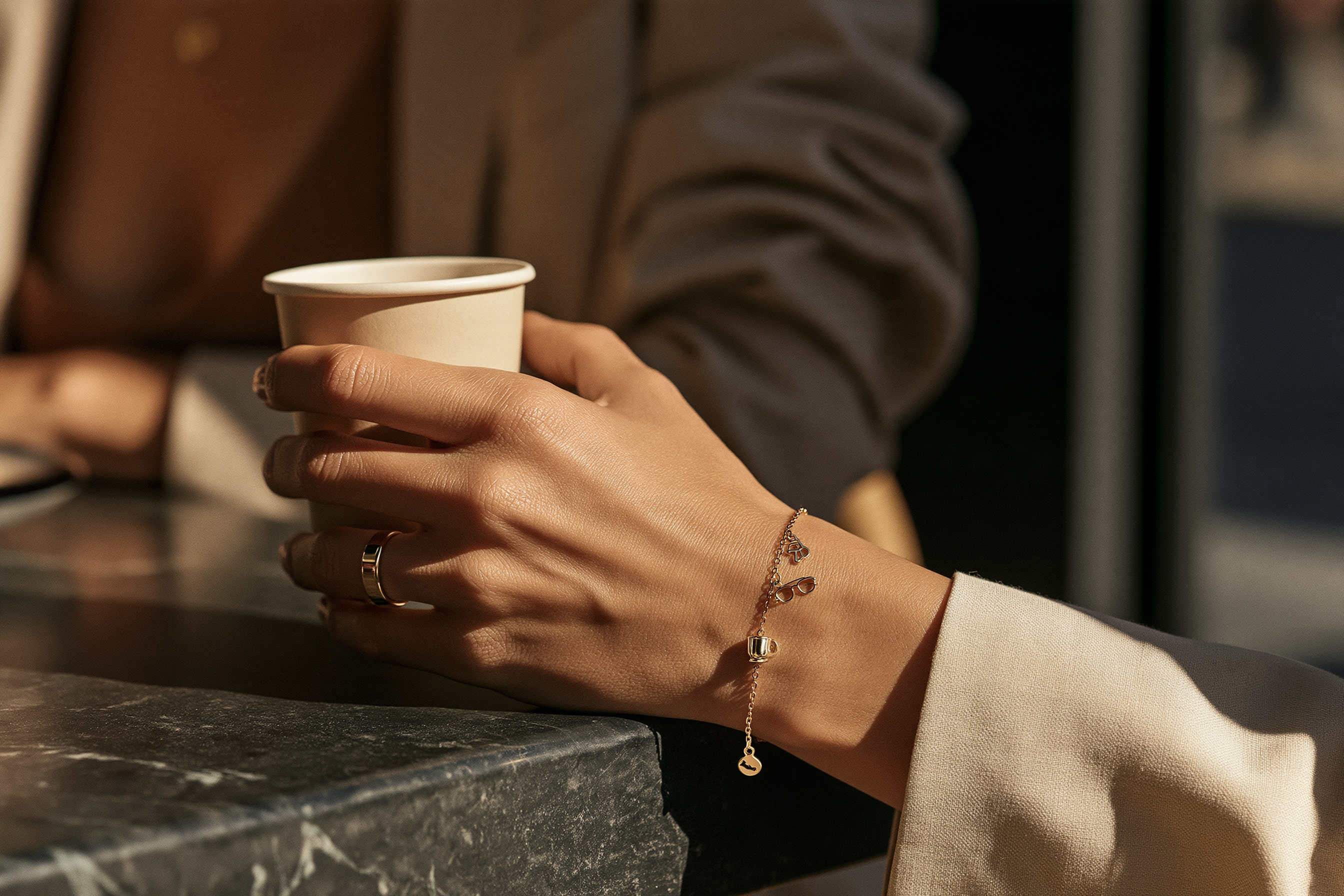 Gold charms inspired by everyday life including coffee and sunglasses symbols