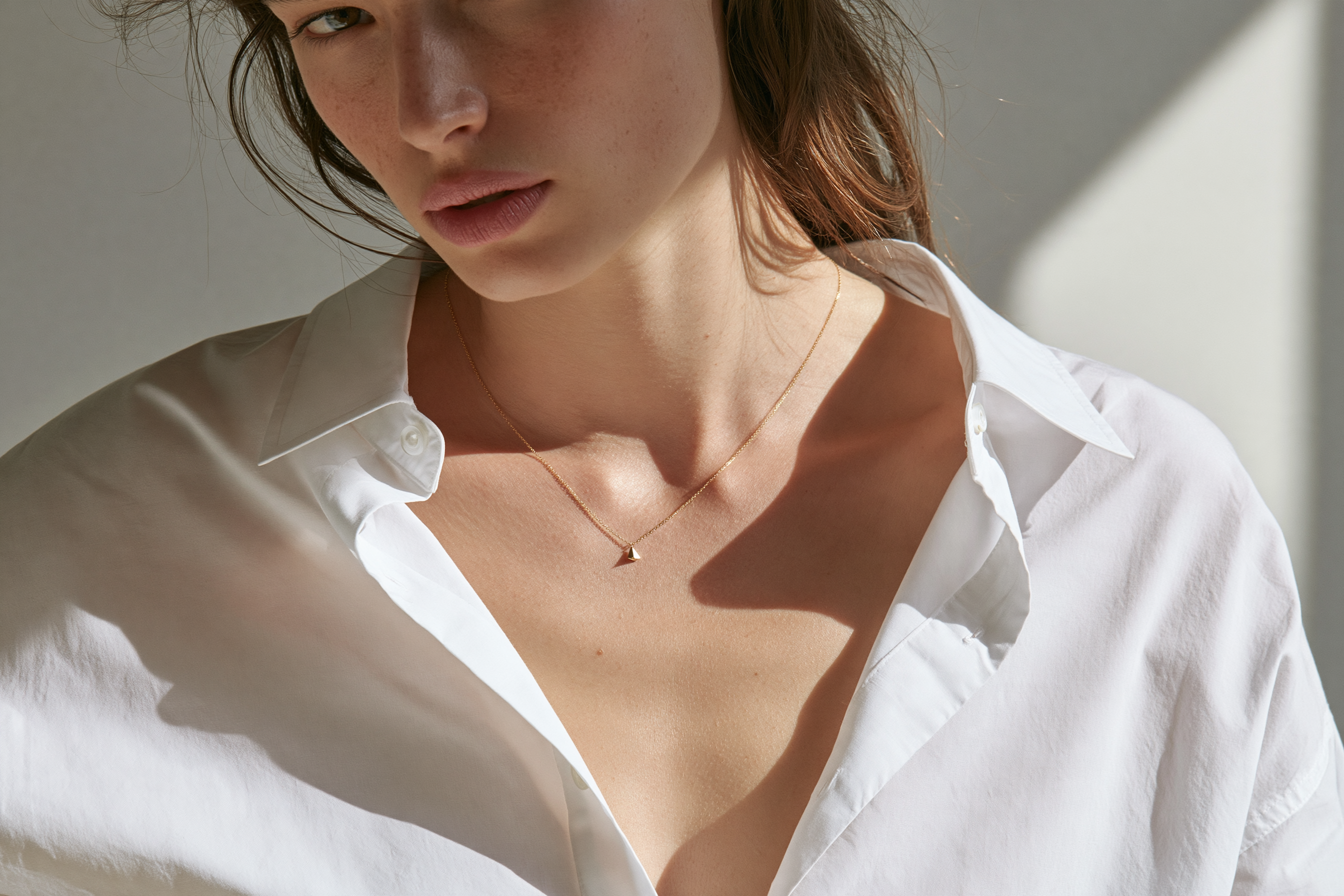 Minimal gold necklace styled with a white shirt in the clean girl aesthetic