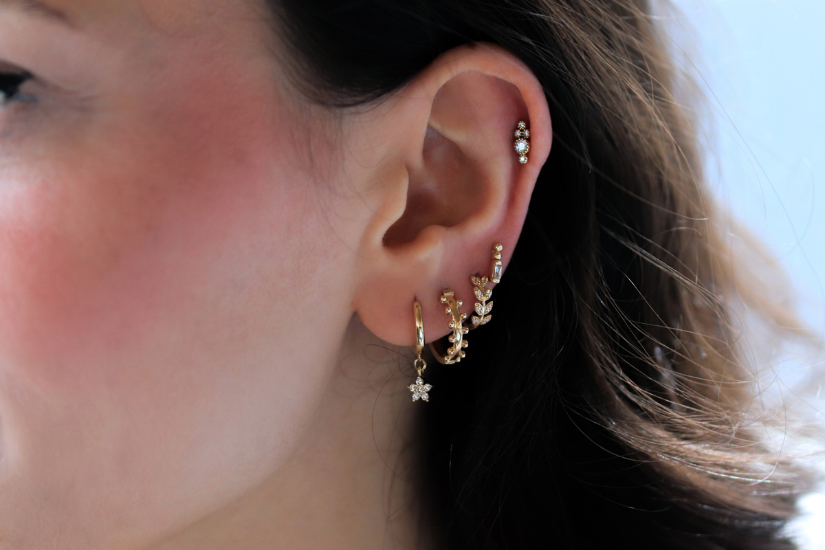 Kulakta hafif altın küpe ve piercing kullanımı