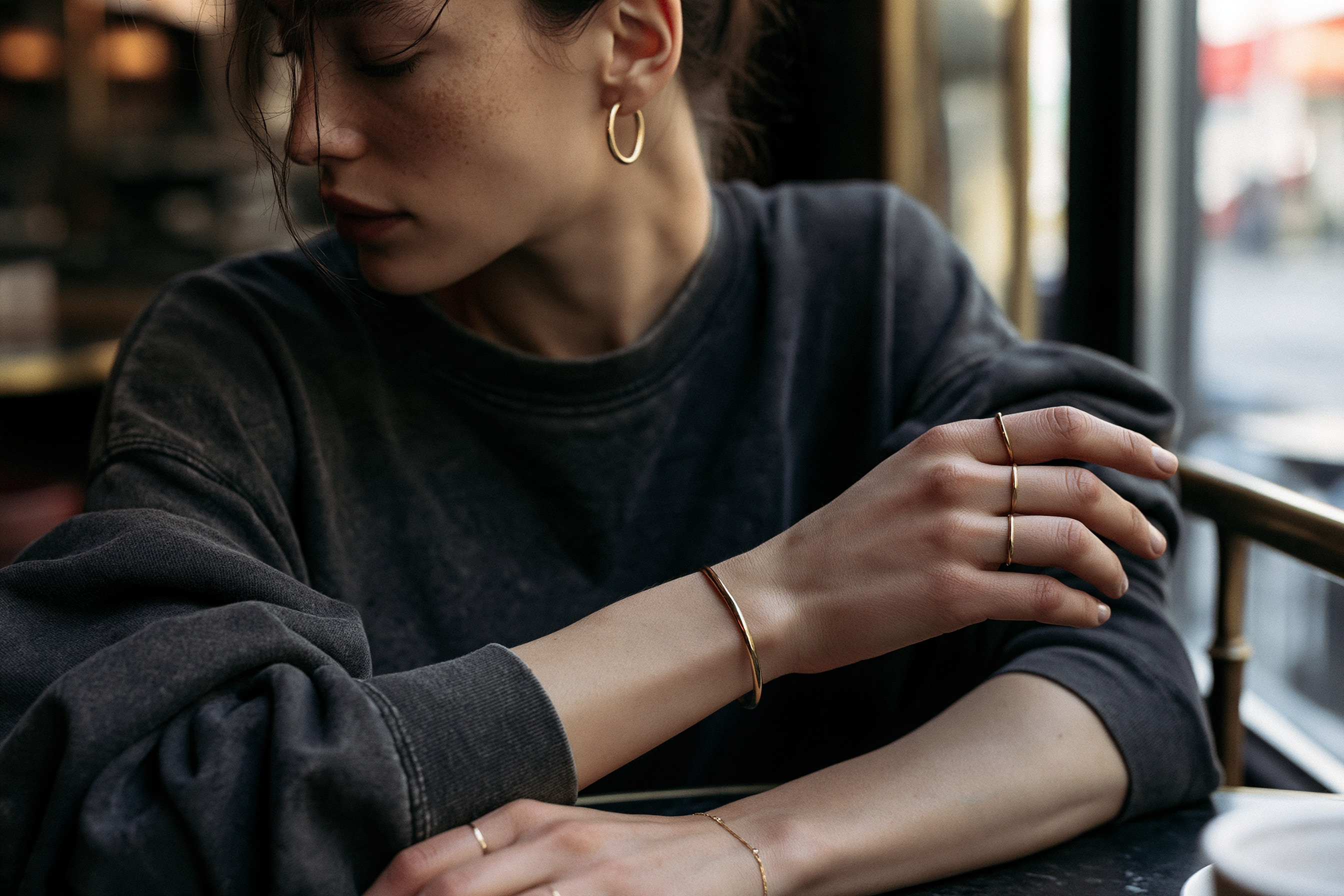 Sade günlük kombini minimal altın yüzük ve küpelerle tamamlayan kadın