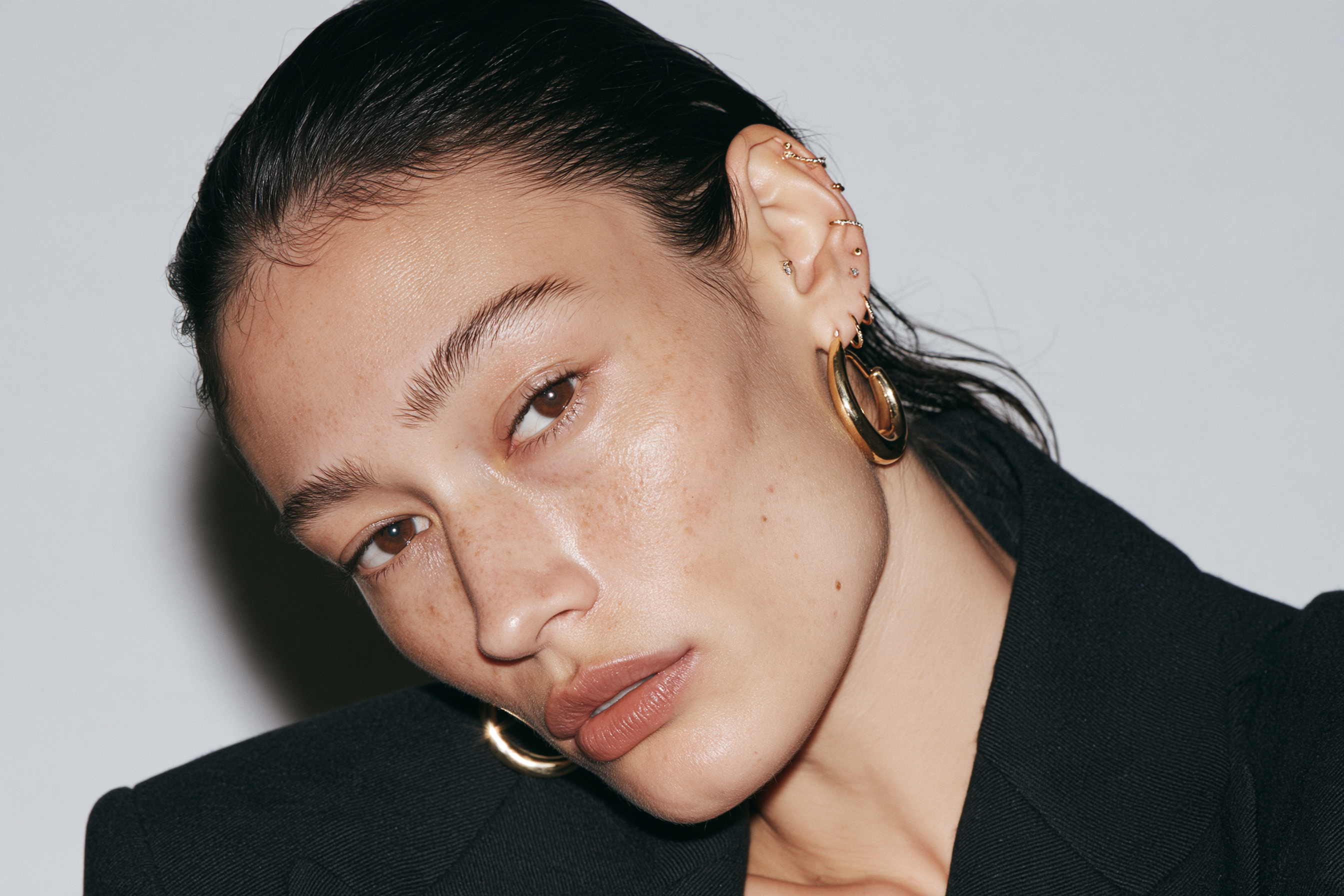 Balanced multi-piercing ear styling with different sizes of gold earrings