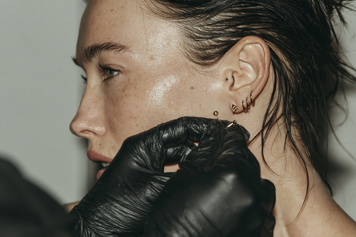 Tragus bölgesinde düz arkalıklı minimal altın piercing